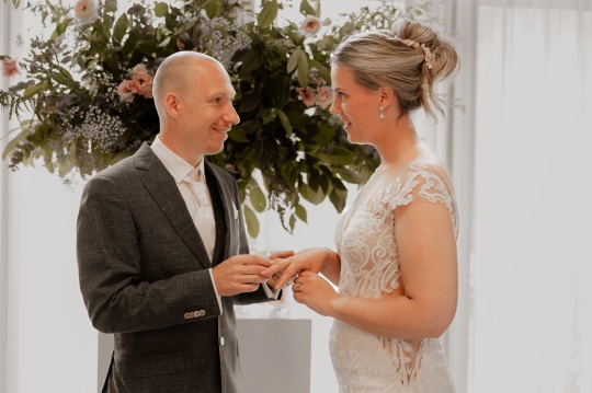 Bruidspaar met ceremoniemeester bij bruiloft