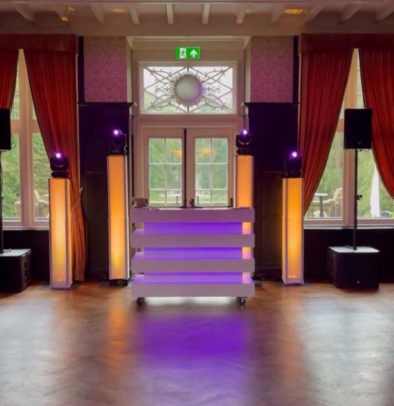 DJ booth met lichtzuilen voor de tuindeuren in een zaal van Kasteel De Hooge Vuursche